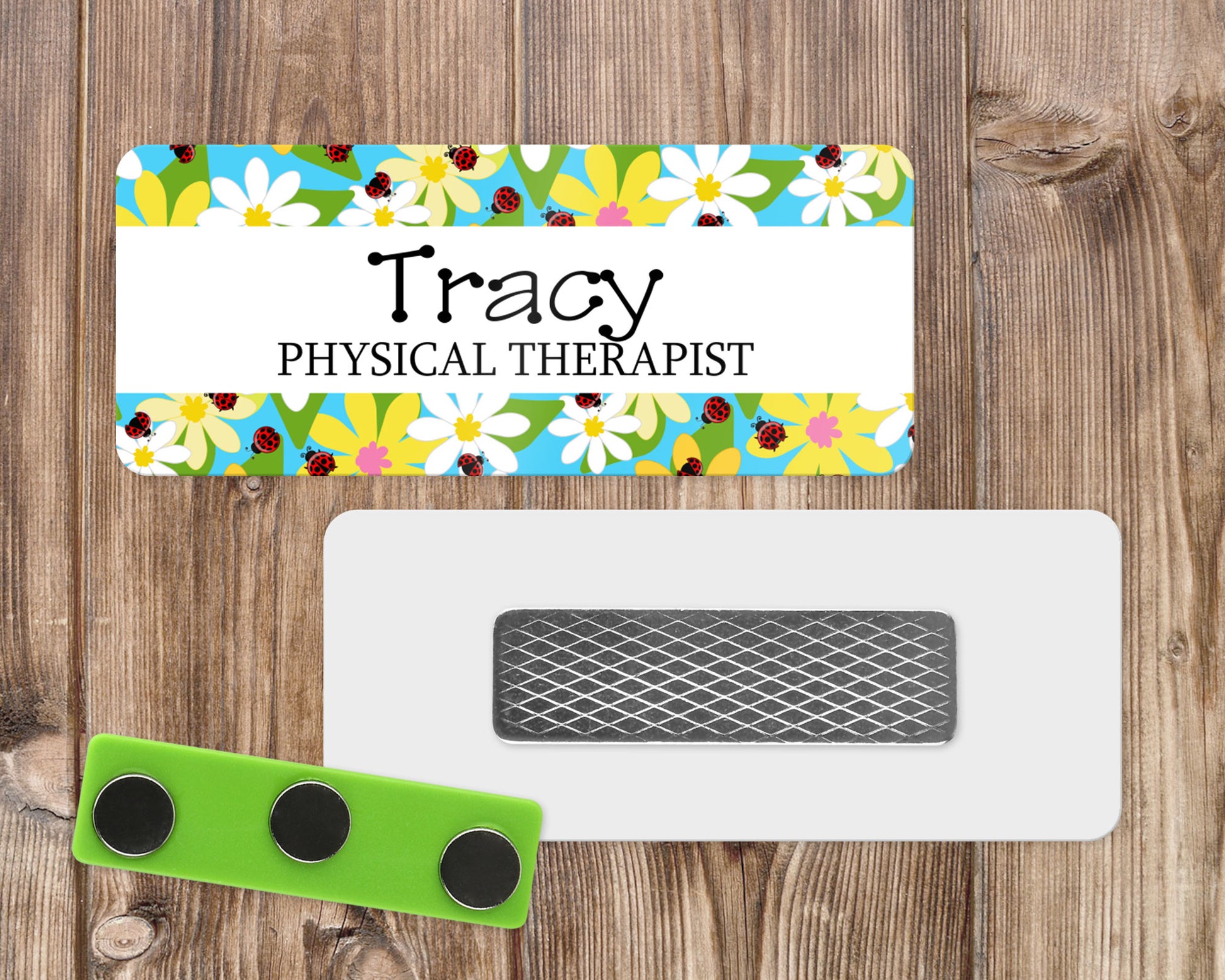 a name tag with a blue background with red ladybugs and yellow and white flowers.